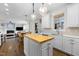 Well-lit kitchen with butcher block island, white cabinets, and stainless-steel appliances extending to the living space at 209 Plyersmill Rd, Cary, NC 27519