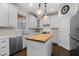 Well-lit kitchen features white cabinets, stainless steel appliances, subway tile backsplash, and butcher block island at 209 Plyersmill Rd, Cary, NC 27519