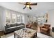 Open-concept living room featuring hardwood floors, a ceiling fan, and large windows with an attached kitchen and dining area at 209 Plyersmill Rd, Cary, NC 27519