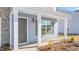 Welcoming entryway with a covered porch, featuring classic white columns and a stylish dark gray front door at 215 Leven Dr, Gibsonville, NC 27249