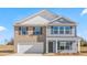 Inviting two-story home featuring brick and blue siding, complemented by dark shutters and a well-maintained front yard at 215 Leven Dr, Gibsonville, NC 27249