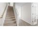 Bright foyer featuring a carpeted staircase, white walls, and a glass door leading to another room at 215 Leven Dr, Gibsonville, NC 27249