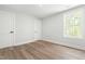 An empty bedroom provides three doors, light grey walls, and wood-look flooring at 230 Sutherland Dr, Franklinton, NC 27525
