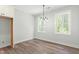 Dining room featuring modern chandelier, two windows, light walls, and wood-look flooring at 230 Sutherland Dr, Franklinton, NC 27525