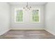 Dining room with light walls, wood-look flooring, windows, and modern light fixture at 230 Sutherland Dr, Franklinton, NC 27525