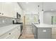 Bright, modern kitchen features white cabinetry, stainless steel appliances, and a gray island with pendant lighting at 230 Sutherland Dr, Franklinton, NC 27525