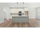 Modern kitchen with white cabinets, gray island, stainless appliances, and wood-look floors at 230 Sutherland Dr, Franklinton, NC 27525