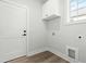 Laundry room boasts white cabinets, modern fixtures, and convenient hookups, blending style with functionality at 230 Sutherland Dr, Franklinton, NC 27525
