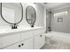 Stylish bathroom featuring dual sinks, oval mirrors, and tub-shower combo with bright tile at 240 Sutherland Dr, Franklinton, NC 27525