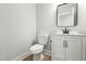 Modern half bathroom featuring a sleek vanity with a mirror and a toilet at 240 Sutherland Dr, Franklinton, NC 27525