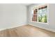 Bright bedroom showcasing a large window with exterior views, light wood floors, and neutral paint creating a calm atmosphere at 240 Sutherland Dr, Franklinton, NC 27525
