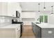 Modern kitchen features white cabinetry, stainless steel appliances, and a large island with a sink at 240 Sutherland Dr, Franklinton, NC 27525