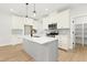 Modern kitchen showcases white cabinets, a sleek island, and stainless steel appliances, perfect for culinary creativity at 240 Sutherland Dr, Franklinton, NC 27525