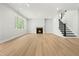 Spacious living room with a cozy fireplace and staircase, perfect for relaxing and entertaining in style at 240 Sutherland Dr, Franklinton, NC 27525