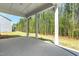 Covered patio with white columns overlooking a heavily wooded backyard at 240 Sutherland Dr, Franklinton, NC 27525
