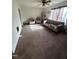 Spacious living room with cozy carpet, a ceiling fan, and natural light at 2408 Stadium Dr # A, Durham, NC 27704