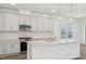 Kitchen island with sleek white cabinets, stainless steel appliances, and hanging lights at 269 Marvel Dr # 138, Rolesville, NC 27571