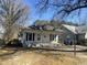 Exterior elevation of cottage-style home with a covered front porch, side driveway and mature trees at 2711 Ashe St, Durham, NC 27703