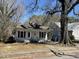 Exterior elevation of cottage-style home with a covered front porch and mature trees in yard at 2711 Ashe St, Durham, NC 27703
