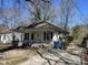 Charming cottage-style home with a covered front porch and dark shutters and driveway at 2711 Ashe St, Durham, NC 27703