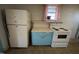 Close-up view of classic appliances, blue cabinetry, and pink curtains in the kitchen at 2711 Ashe St, Durham, NC 27703