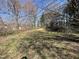 This image shows a grass covered parcel of land that is surrounded by trees at 2711 Ashe St, Durham, NC 27703