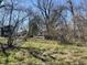 The image shows a grass covered parcel of land with homes in the background at 2711 Ashe St, Durham, NC 27703