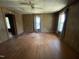 Spacious living room with hardwood floors, wood paneled walls, and natural light from windows at 2711 Ashe St, Durham, NC 27703