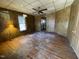 Empty living room featuring hardwood floors, paneled walls, ceiling fan, and natural light at 2711 Ashe St, Durham, NC 27703