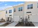 Townhome exteriors showing the garages, landscaping and siding against a cloudy blue sky at 280 Chesapeake Commons St # 151, Garner, NC 27529