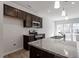 Modern kitchen with stainless steel appliances, granite countertops, and dark wood cabinetry at 280 Chesapeake Commons St # 151, Garner, NC 27529