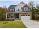 Beautiful two-story home featuring a stone facade, inviting front porch, and a two-car garage at 3154 Armeria Dr, Apex, NC 27502