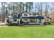 Stunning two-story home boasts a white painted brick exterior, black accents, and a lush green lawn at 38 Kingbird Ln, Chapel Hill, NC 27517