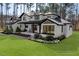 Beautiful two-story home with white painted brick, black accents, and professionally landscaped front yard at 38 Kingbird Ln, Chapel Hill, NC 27517