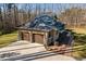 Exterior elevation view of a three-car garage on a home with a brick facade at 38 Kingbird Ln, Chapel Hill, NC 27517