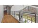 Bright hallway with wood flooring, large windows, and modern railings offering views of the outdoor scenery at 38 Kingbird Ln, Chapel Hill, NC 27517