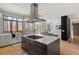 Open-concept kitchen featuring an island cooktop, modern range hood, and expansive forest views at 38 Kingbird Ln, Chapel Hill, NC 27517