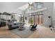 Bright living room boasts large windows, high ceilings, hardwood floors and a comfortable gray sofa at 38 Kingbird Ln, Chapel Hill, NC 27517