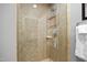 Close-up of the glass-enclosed shower featuring beige tiles and a chrome showerhead at 400 W North St # 804, Raleigh, NC 27603