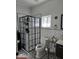 Modern bathroom featuring elegant black and white patterned tile flooring, glass shower, and stylish fixtures at 431 S Harrison Ave, Cary, NC 27511