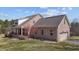 Exterior view of a brick home with a metal roof, side-entry garage and porch at 4420 Bunton Swaim Rd, Liberty, NC 27298