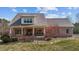 Charming brick home featuring a metal roof, covered front porch, and professionally landscaped yard at 4420 Bunton Swaim Rd, Liberty, NC 27298