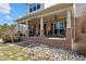 Inviting front porch with brick accents, string lights, and seating arrangements at 4420 Bunton Swaim Rd, Liberty, NC 27298