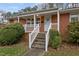 Quaint brick home featuring front porch with white picket railings at 461 Camp Rd, Burlington, NC 27217