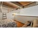 Open bedroom with a sofa features exposed ceiling beams, hardwood floors, and a ladder at 500 N Duke St # 53104, Durham, NC 27701