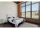 Bright bedroom features exposed brick wall, large window, and modern bed frame with floral bedding at 500 N Duke St # 53104, Durham, NC 27701