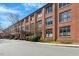 Wide exterior shot showcasing the brick condominium complex with covered entrances and landscaping at 500 N Duke St # 53104, Durham, NC 27701