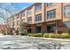 Brick condominium complex featuring a covered entrance, lush green landscaping, and ample parking space at 500 N Duke St # 53104, Durham, NC 27701