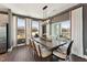 Modern dining area with a long table, stylish lighting, hardwood floors, and access to a balcony at 600 Hedrick Ridge Road # 306, Cary, NC 27519