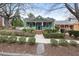 Lovely green home with white trim, a cozy front porch, and manicured landscaping at 603 Polk St, Raleigh, NC 27604